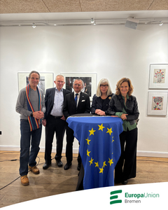 Einige Vorstandsmitglieder der Europa-Union Bremen vor einer Europaflagge.